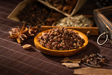 Chinese traditional seasoning five spice powder and raw materials on retro background
