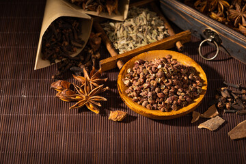 Chinese traditional seasoning five spice powder and raw materials on retro background
