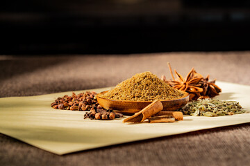 Chinese traditional seasoning five spice powder and raw materials on retro background
