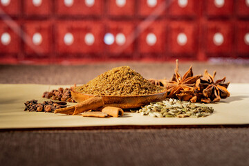 Chinese traditional seasoning five spice powder and raw materials on retro background
