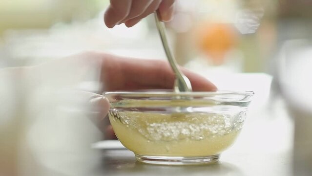 Confectioner preparing gelatine in a glass bowl.

