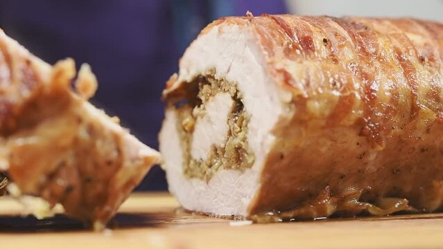 Slicing rolled pork loin with apples.
