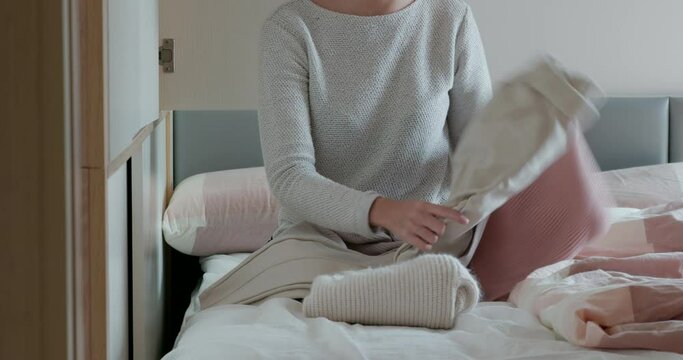 Woman fold the clothes, do housework at home