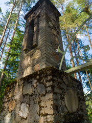 An old medieval stone tower building. Ruins of an ancient Gothic gate in the forest. 25 July 2022, Minsk, Belarus
