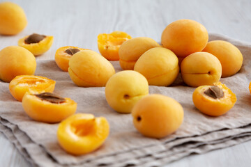 Raw White Apricot Angelcots on a white wooden surface, low angle view.