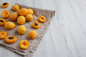 Raw White Apricot Angelcots on a white wooden background, low angle view. Copy space.