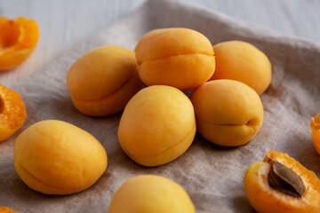 Raw White Apricot Angelcots on a white wooden surface, side view.