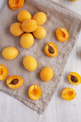 Raw White Apricot Angelcots on a white wooden background, top view. Flat lay, overhead, from above.