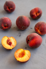 Raw Organic Yellow Peaches on a gray background, side view.
