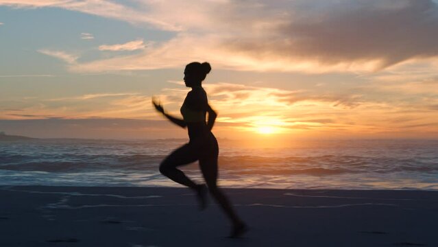 Fast, fit and active jogger running by the ocean and beach shore with sunset sky background and copy space. A sporty female athlete exercising or doing endurance workout outdoors with a scenic view