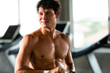 caucasian athlete man person drink a bottle of fresh water after workout in sport gym, adult male...