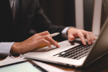 Fototapeta premium closeup business hand working to typing computer laptop keyboard in modern office or home workplace desk table, businessman using notebook for online technology communication job by using cyberspace