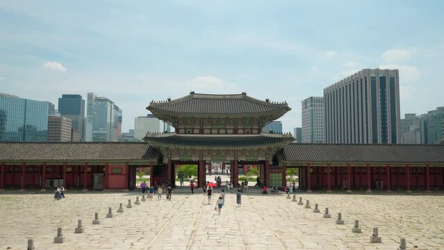 Tourists Entering Geunjeongjeon Hall Walking through Geunjeongmun Gate of Gyeongbokgung Palace  -establishing view against sky