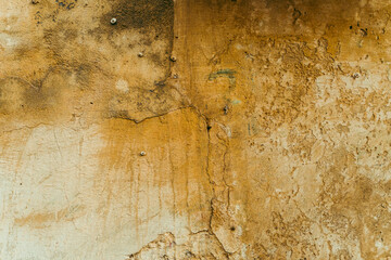 Destroyed cracked wall background, brown light texture, paint streaks.