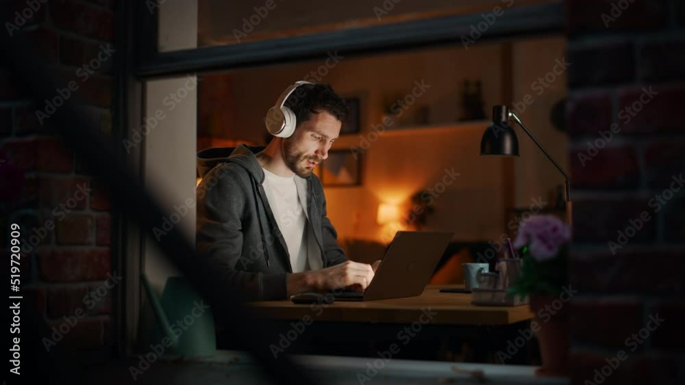 Poster Professional Tireless Software Developer Stretches and Continues Working on Laptop, Writing Code and Working on the Project. Remote Work at Night Time Concept. View From Outdoors into Window.