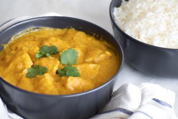 Chicken korma in a bowl.  Traditional Indian curry with rice on the table. 