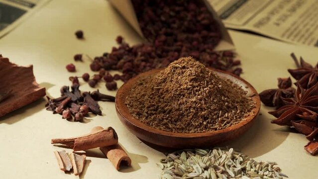 Chinese traditional seasoning five spice powder and raw materials on retro background