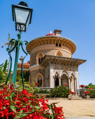 Palace of Monserrate in Portugal. With a lantern and red flowers in the foreground. - obrazy, fototapety, plakaty