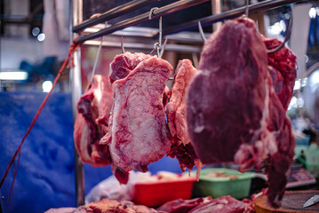 Beef hung on iron hooks for sale in Amorn Nakhon Naklua Fresh Food Market, Thailand.