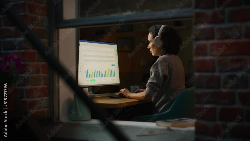 Leinwandbilder Hispanic Woman Developer Working in Evening on a Desktop Computer in Home Environment. Beautiful Diverse Latin Female Software Engineer is Checking Her Tasks at the Dashboard.