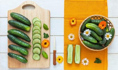 Harvest of organic farm cucumbers in a basket. Cut into round pieces on a cutting board for salad...