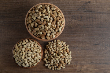 Bowl full of dried mulberry on a wooden background
