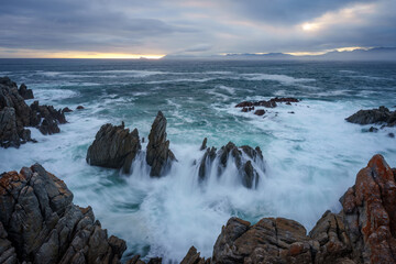The beautiful coastline at De Kelders with a view across Walker Bay towards Hermanus, Overberg, Western Cape, South Africa.