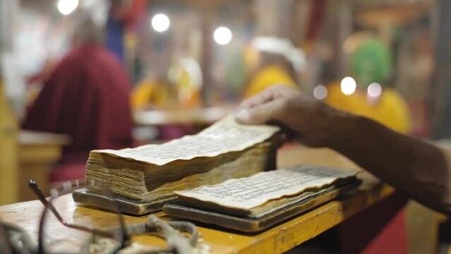 Old Tibetan Monk Reading Scriptures During Morning Prayer Routine In Thiksey Monastery In Ladakh India - close up shot