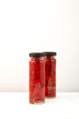 Two glass jars with delicious Red pickled mini peppers. Preserved pepper, spicy appetizer. Vertical orientation, copy space