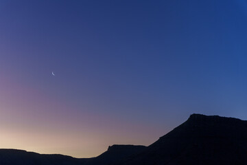 Sunset sky, crescent moon and scenic view of Karoo National Park, Beaufort West, Western Cape, South Africa
