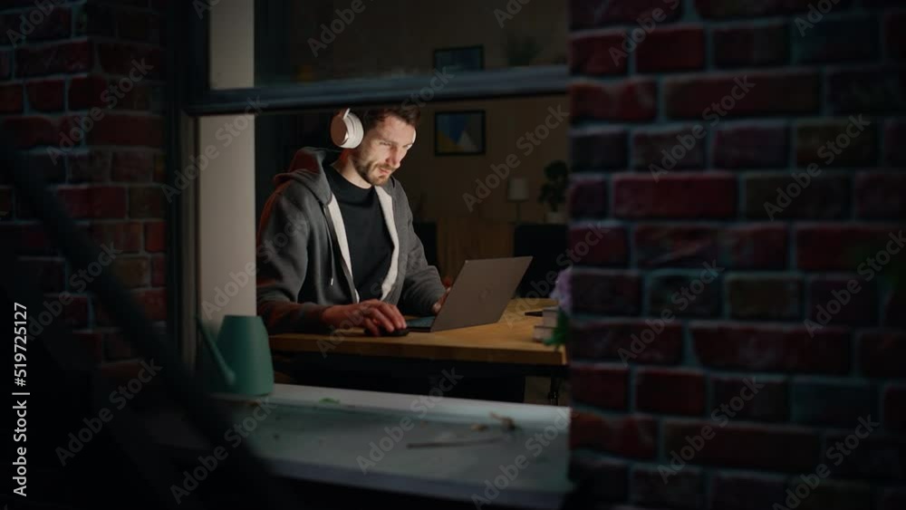 Poster Software Developer Programming on Laptop Late Night. Male Specialist Browsing Internet, Listening to Podcast, Does Creative Marketing. Remote Work from Home Concept. Medium Close-up Portrait.