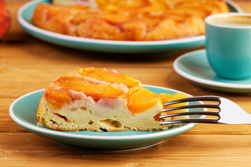Piece of homemade pie with peaches and cup of coffee espresso on wooden table. Shallow focus.