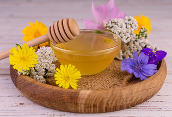 Obraz na płótnie Canvas Fresh floral honey with a glass bowl on a wooden tray. 