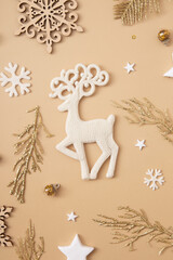 Deer and Christmas decoration on pastel beige background. Holiday present concept. Top view. Vertical format