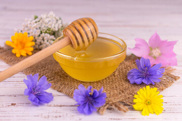 Obraz na płótnie Canvas Fresh flower honey with a glass bowl on a white wooden background. 