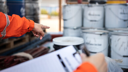 Action of a safety officer is point to chemical box at the factory storage area during perform...