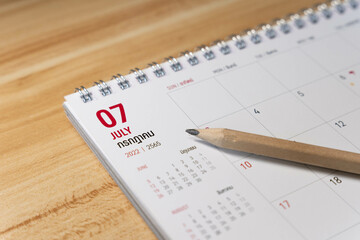 Jul month 2022 Calendar page with pencil business planning concept on wooden background