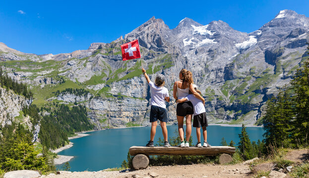 happy family travaling in Switzerland,  Oeschinensee lake and alps mountain