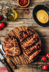 Obraz na płótnie Canvas Fresh delicious juicy steaks with on a rustic wooden background. Pork steaks with tomato and mustard sauce