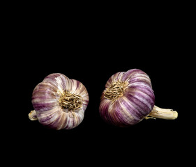  two heads of garlic on a black background