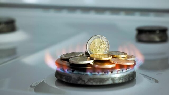 Concept of gas crisis. 2 Euro coins is burning on a kitchen stove burner and fall when the gas end. High prices of natural resources. Fire flame. Utility debt. Energy war. Saving home budget. Finance.