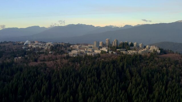 Towering Buildings Of Simon Fraser University On The Forested Mountain Of Burnaby In BC, Canada. Wide Aerial