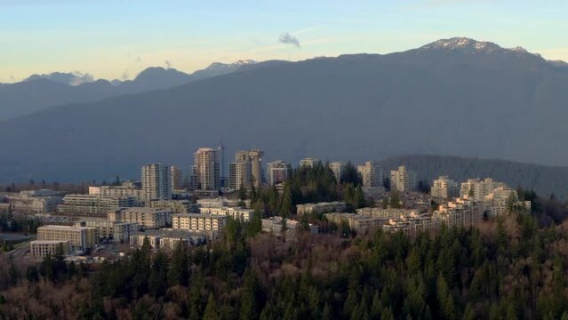 Public Research Institution Of Simon Fraser University Over Thick Forest Mountain Of Burnaby Elevation In BC, Canada. Wide Aerial