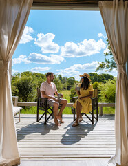 couple on safari in South Africa, Asian women and European men at a tented camp lodge during the...