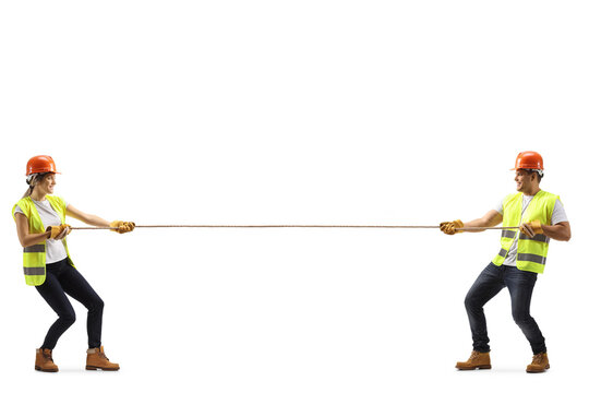 Full length profile shot of a male and female construction worker pulling a rope