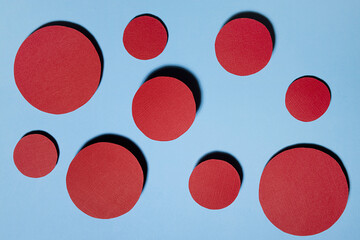 Colorful abstract dotted background with red textured circles fly on blue color with shadow in funny playful minimalist style.