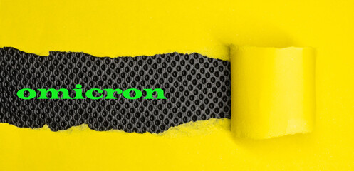   Omicron. Word written yellow cardboard under modern black background.