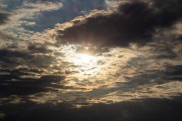 bright yellow sun peeking out from behind the clouds