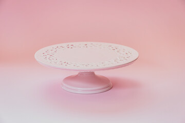 Empty  ceramic pink cake stand on a pastel pink table with copy space, selective focus