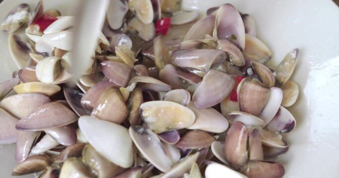 Delicious Peruvian food of ceviche with shells or Palabritas, onion, corn and red hot pepper.